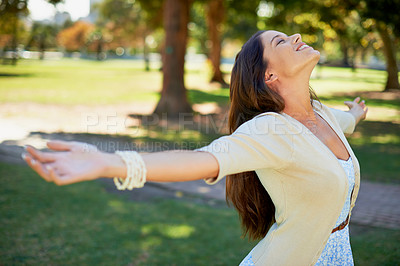 Buy stock photo Shot of a carefree young woman enjoying a day at the park
