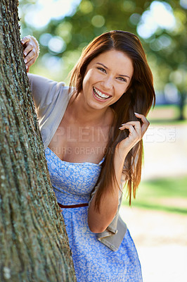 Buy stock photo Woman, woods and tree with smile, portrait and happiness with joy and green fun for nature. Lady, laugh and sun with grass, forest and bokeh for exited playful summer with optimism and sunshine