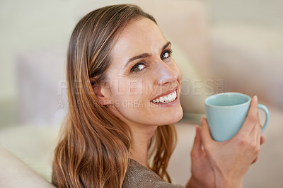 Buy stock photo Portrait of an attractive woman drinking coffee while sitting on the sofa