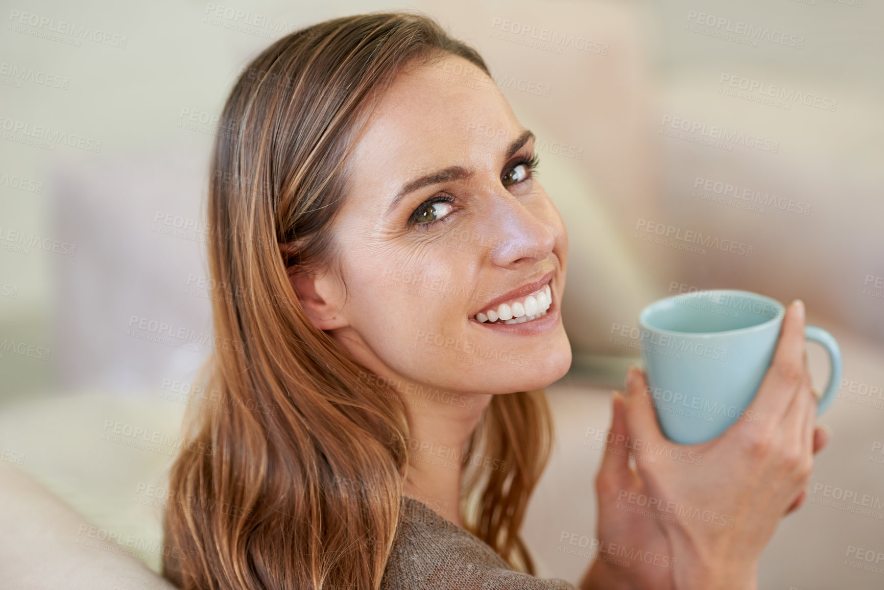 Buy stock photo Portrait of an attractive woman drinking coffee while sitting on the sofa
