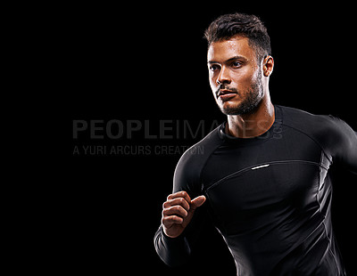 Buy stock photo Studio shot of a handsome young man running against a black background