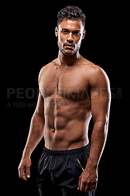 Buy stock photo Studio portrait of a handsome bare-chested young athlete standing against a black background