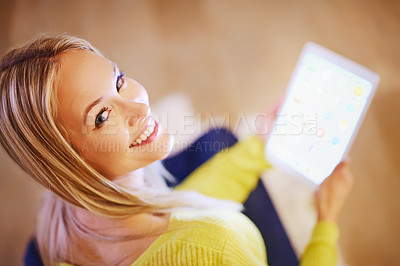 Buy stock photo Shot of an attractive blonde woman relaxing at home with a digital tablet