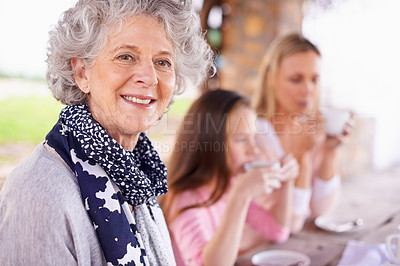 Buy stock photo Portrait, grandma or mama to relax, child or family by drinking tea, happy or bonding together. Female pensioner, woman or girl at table in retirement garden in multigenerational coffee hangout