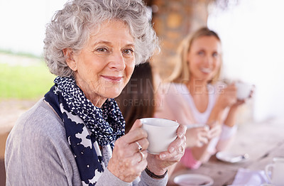 Buy stock photo Shot of three generations of the woman of the women of a family having tea outside