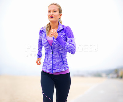 Buy stock photo Shot of a young woman in sportswear standing at the beach