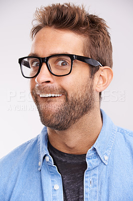 Buy stock photo Silly face, nerd and man with glasses, portrait and goofy guy on a grey studio background. Model, eyewear and person with facial expression and reaction with mindset and happiness with comedy or joke