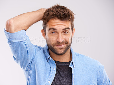 Buy stock photo Studio shot of a handsome young man scratching his head against a gray background