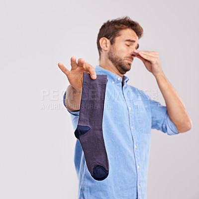 Buy stock photo Man, smelly socks and close nose for poor hygiene with clothes, bad odor or stink with disgust isolated on white background. Unpleasant, dirty and foul with negative reaction for stench in studio