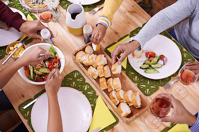 Buy stock photo A cropped high angle view of a group of people sharing a meal around a table