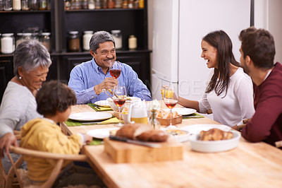 Buy stock photo Happy, big family and food with wine at dinner table in thanksgiving, bonding or get together at home. Grandparents, parents and grandchild with smile in happiness for meal, feast or weekend at house