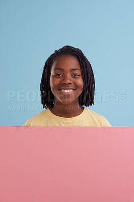 Buy stock photo Portrait, banner or happy boy child with mockup in studio for announcement, offer or info on blue background. Poster, face or teen model smile with billboard presentation for news, promo and opinion