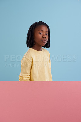 Buy stock photo Teenager, portrait and poster mockup in studio for advertising of fashion, style and cool clothes. Face of an african child, model or kid with space and creative information on a blue background