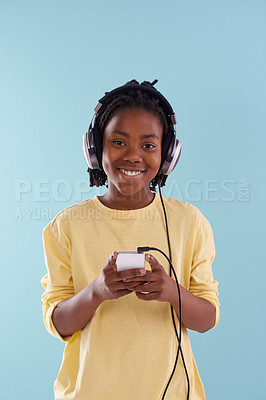 Buy stock photo Music, phone and boy portrait with headphones in studio for internet, playlist or search on blue background. Smartphone, radio and teen model with app for podcast, streaming or sign up subscription