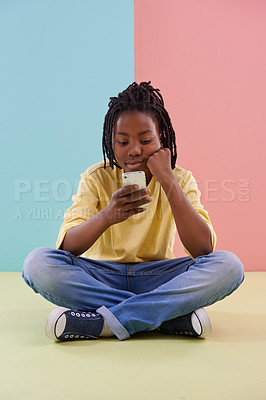 Buy stock photo Search, phone and bored boy child on a floor with social media, reading or ebook in his home. Smartphone, lazy or African teen with app and chill sign up or watching video