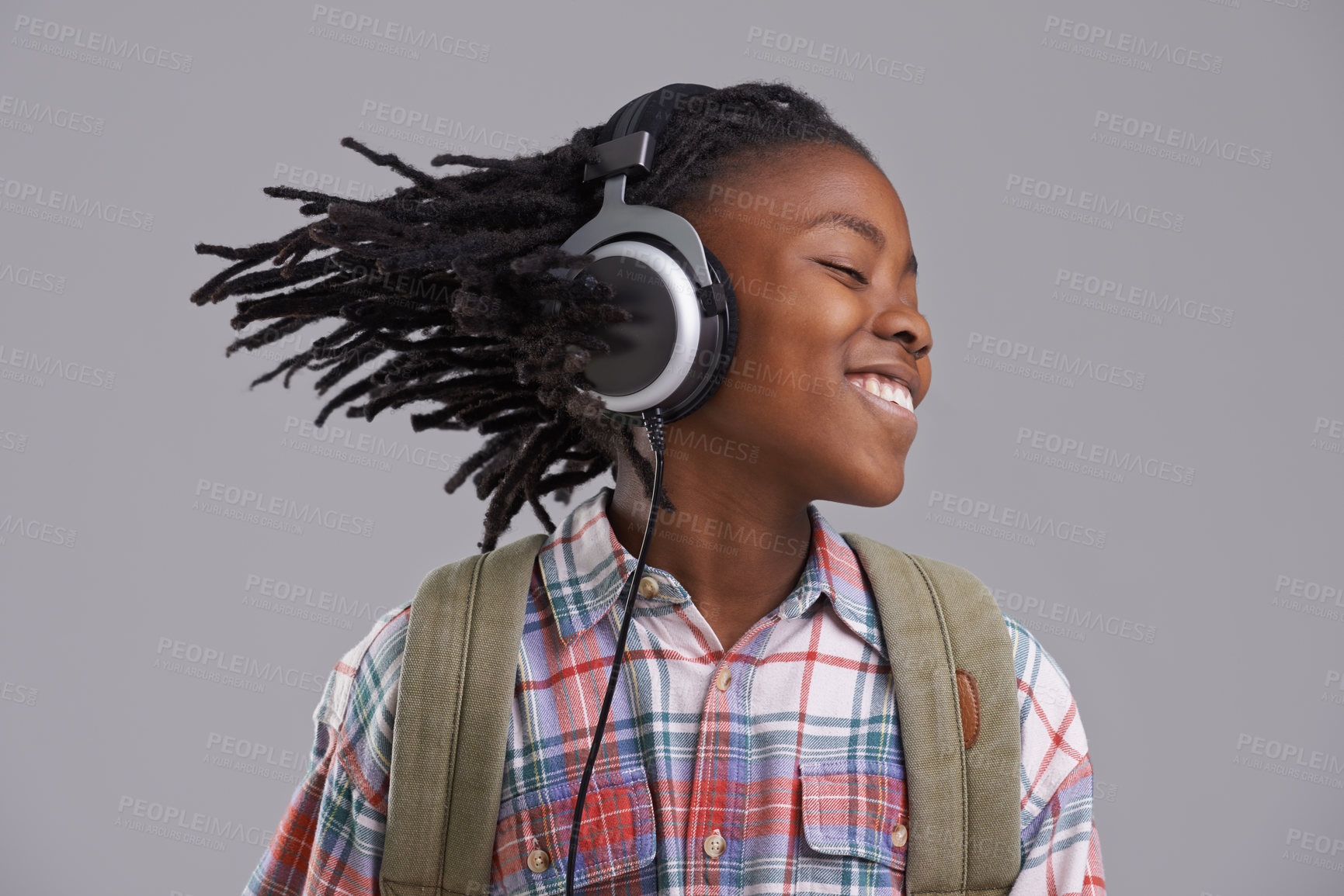 Buy stock photo An African-American boy listening to music over his headphones