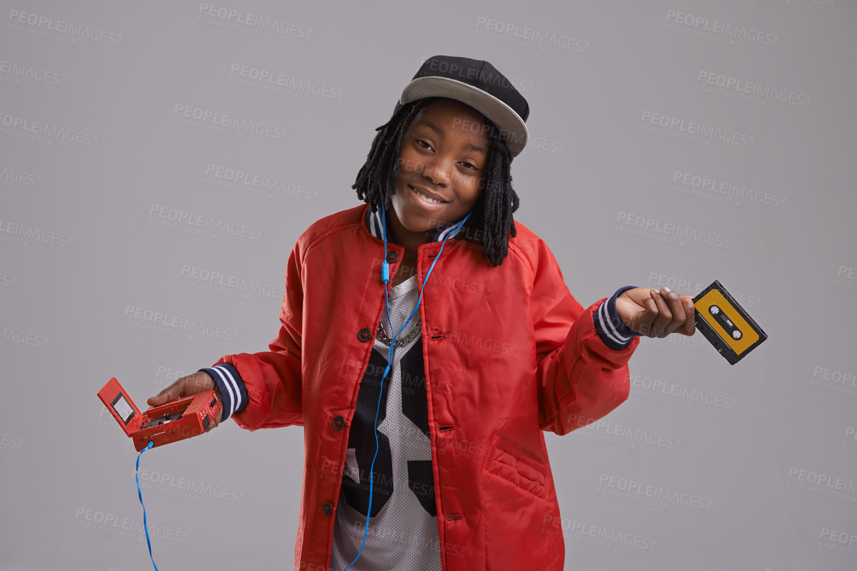 Buy stock photo Music, shrug and child on gray background with cassette for listening to song, audio and radio. Fashion, youth and young African boy with retro tech for track playlist in trendy clothes in studio