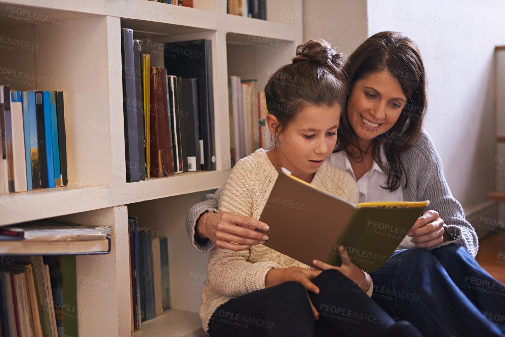 Buy stock photo Bookshelf, mother and daughter with reading on floor, language and help for studying with education. Mom, girl child and story with literature, fantasy and development with learning at family house