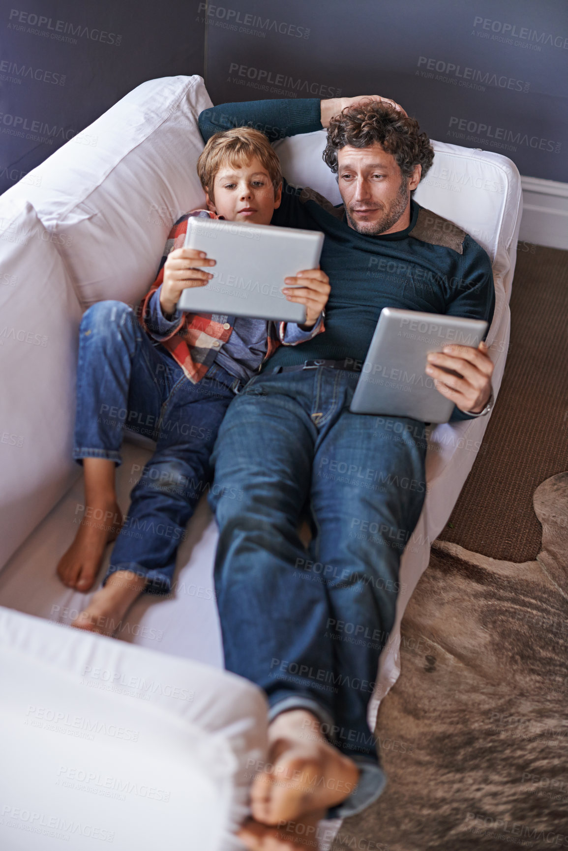 Buy stock photo Father, son and tablet for gaming on sofa together, technology and online streaming for bonding at home. Digital world, internet and man with boy child in living room, gamer app and entertainment