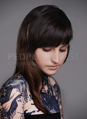 Buy stock photo Woman, tattoo and fashion with body art for beauty, makeup or cosmetics on a gray studio background. Face of calm female person, young model or skin artist in relax with cool design or creativity