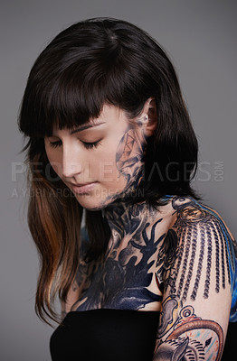 Buy stock photo Calm woman, tattoo and fashion with body art for beauty, makeup or cosmetics on a gray studio background. Face of female person, young model or skin artist in relax with cool design or creativity