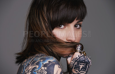 Buy stock photo A cropped studio portrait of a beautiful tattooed young woman