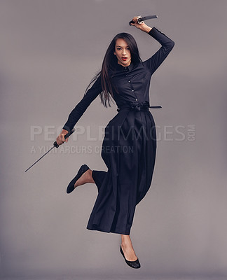 Buy stock photo Ninja, swords and woman samurai in a studio jumping for a martial arts or assassin fighter skill. Fantasy, cosplay and female model in a warrior costume with blade isolated by a gray background.