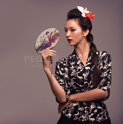 Buy stock photo Japanese woman, fashion and traditional fan with confidence in studio on brown background for culture, style and elegant. Female person, shirt and flower in head with designer clothes or outfit