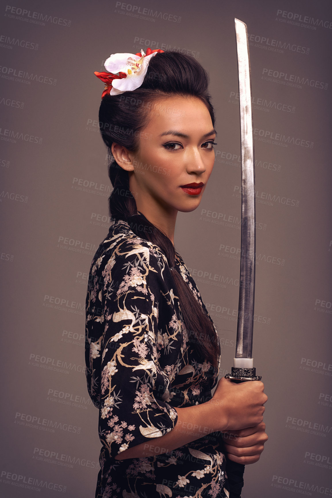 Buy stock photo Studio shot of an attractive young woman holding a samurai sword