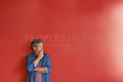 Buy stock photo A mature man standing against a red background