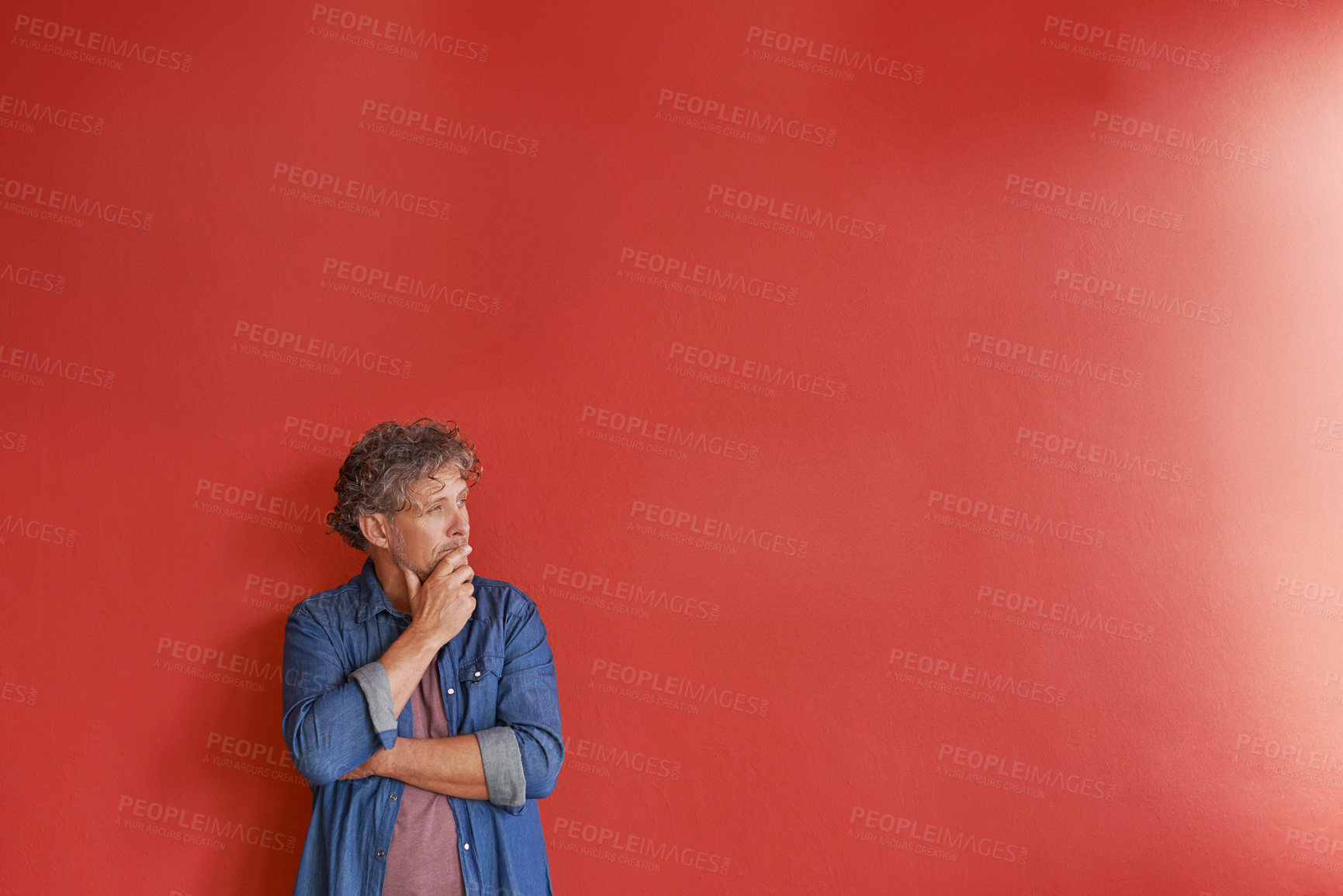 Buy stock photo A mature man standing against a red background