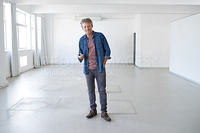 Buy stock photo A portrait of a mature man standing in an empty room holding building plans