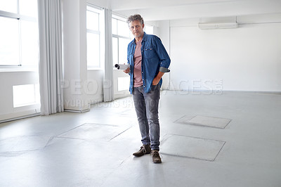 Buy stock photo A portrait of a mature man standing in an empty room holding building plans