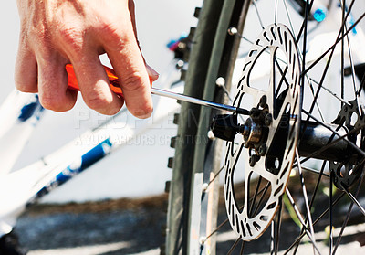 Buy stock photo A cropped view of a man fixing his bicycle 