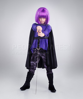 Buy stock photo Little girl, superhero and halloween dress up posing with sword against a grey studio background. Portrait of girl child playing super hero with purple hair, costume or cosplay of a warrior vigilante