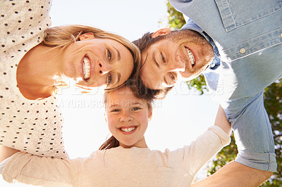 Buy stock photo A low angle shot of a happy family in a huddle