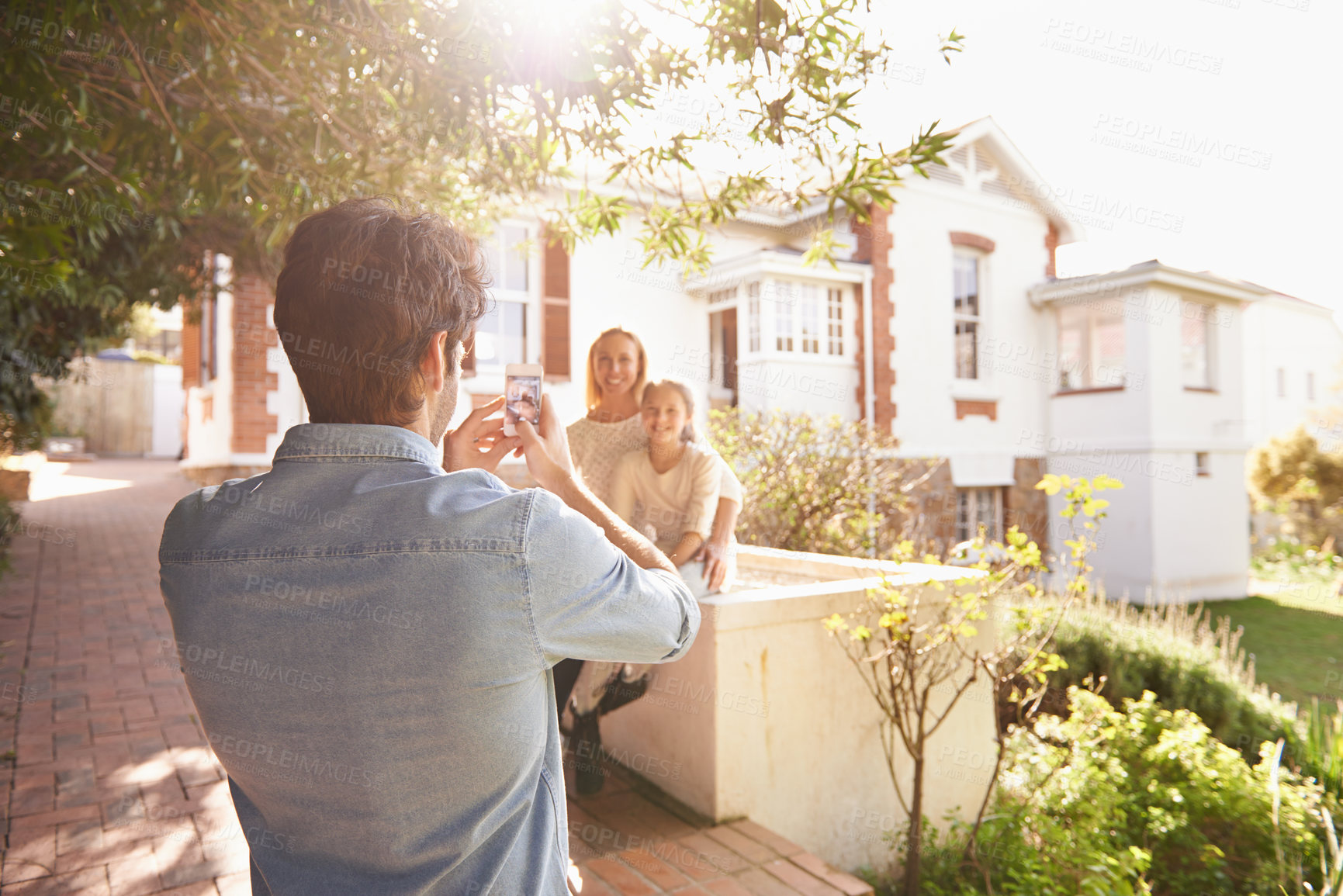 Buy stock photo Father take picture of mother and girl by home for memories, social media post and bonding. New house, photograph and dad taking photo of mom and child for happiness, relaxing and smile on property