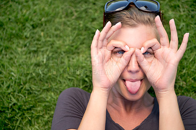 Buy stock photo Portrait, hand glasses and woman with tongue out for funny face, goofy or silly in outdoor garden. Top view, comic and female person joking for humor, finger shape gesture and playful mood in park