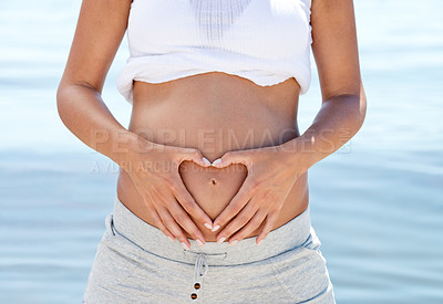 Buy stock photo Pregnant woman, mom and heart hands on belly at beach, love and family with wellness, self care and ocean fresh air. Health, pregnancy and motherhood with maternity, prenatal and baby bump outdoor