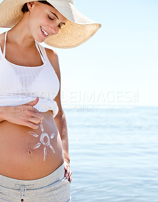 Buy stock photo Pregnant woman, mom and sun drawing on belly with sunscreen, protection and summer at beach. Sea, travel and happy mother, health and wellness with skincare, vacation and sunblock for moisturizer 