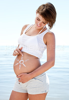 Buy stock photo Summer, beach and pregnant woman outdoor with sunscreen on stomach with happiness. Healthy, pregnancy and care for body with skincare, cream and lotion to protect skin at sea on holiday or vacation