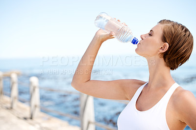 Buy stock photo Woman, drinking water and outdoor at beach for health, fresh air and fitness in nature, h2o and ocean. Nutrition, detox and liquid for thirst, hydration and exercise by the coast with wellness 