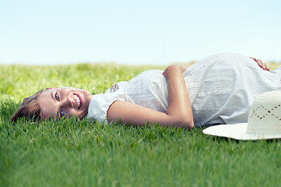 Buy stock photo A pretty woman lying on the grass outdoors and relaxing in the sunshine