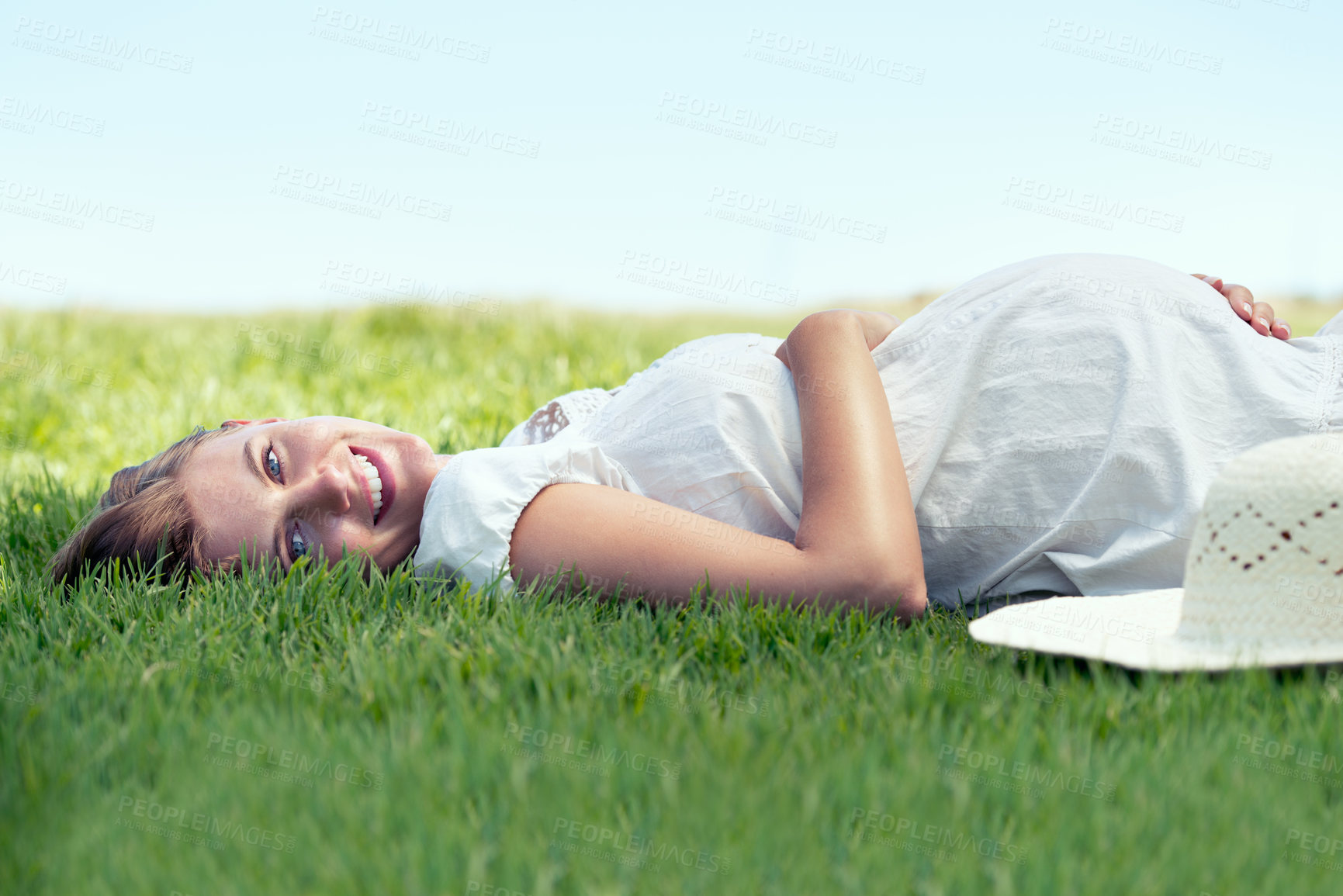 Buy stock photo A pretty woman lying on the grass outdoors and relaxing in the sunshine