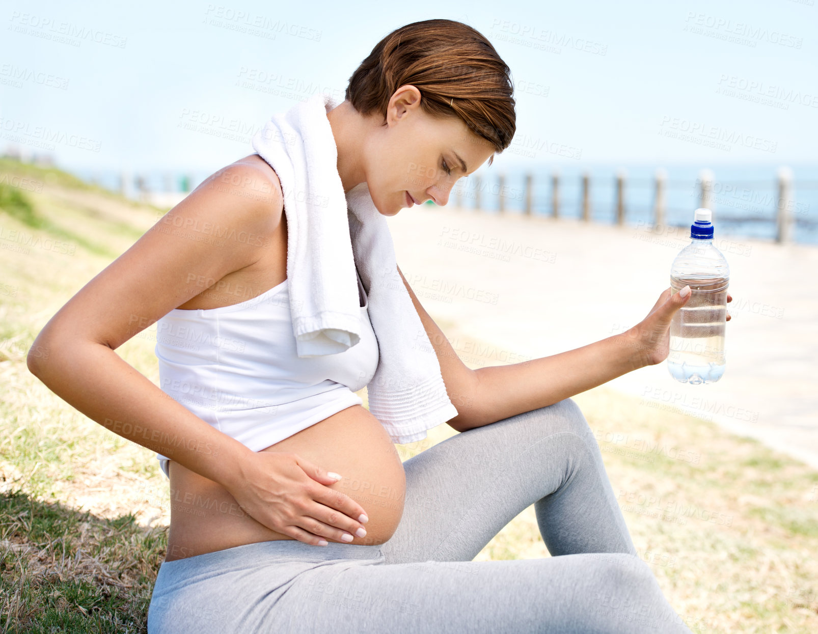 Buy stock photo A pregnant woman resting from her workout outdoors