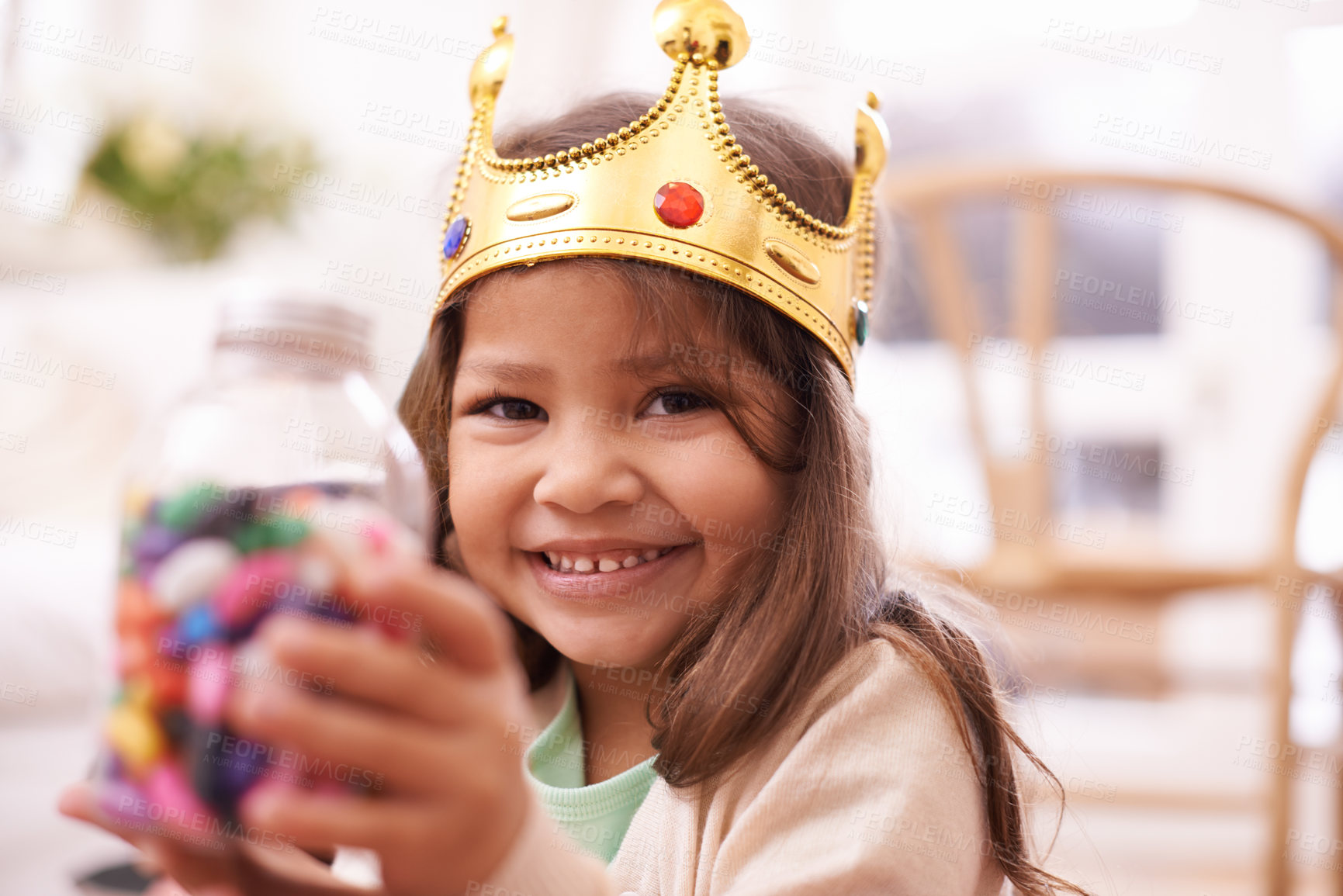Buy stock photo A cute little girl dressed up as a princess while eating candy at home