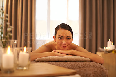 Buy stock photo Candle, relax and portrait of woman on massage table at hotel for self care, stress relief and wellness. Female person, peace and zen face at spa for body health, hospitality and spiritual healing