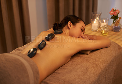 Buy stock photo Relax, woman and massage with stone at spa for luxury self care, organic body health and wellness. Table, towel and zen female person with hot rock for detox, stress relief and spiritual healing