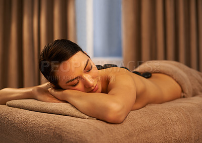 Buy stock photo Sleep, woman and massage with stone at spa for luxury self care, organic body health and wellness. Towel, table and female person with peace for hot rock therapy, stress relief and spiritual healing