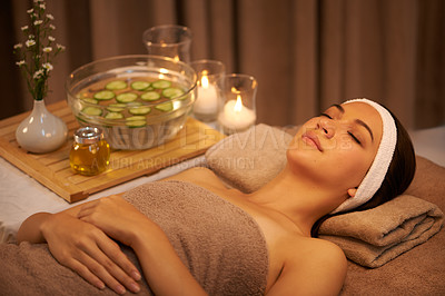 Buy stock photo Sleeping, relax and woman at massage table in spa with cucumber for peace, calm or skincare. Body, salon and person resting for aromatherapy with candles for natural beauty or health with eyes closed